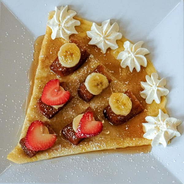 La Crepe Og Gourmet's crepe with bananas, heart-shaped strawberries, whipped cream, and powdered sugar.